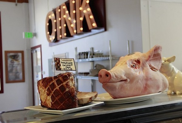 A pig head on a counter and a sign that reads "OINK"