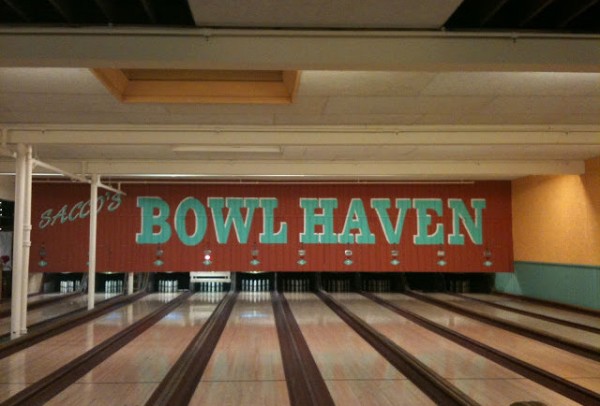 'Bowl Haven' printed on the wall behind a row of lanes