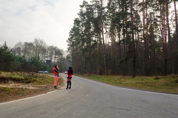 Two sex workers talking on the side of the road