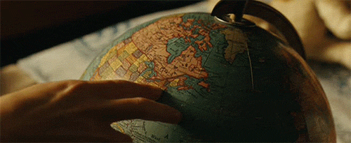 A person walking fingers along a globe