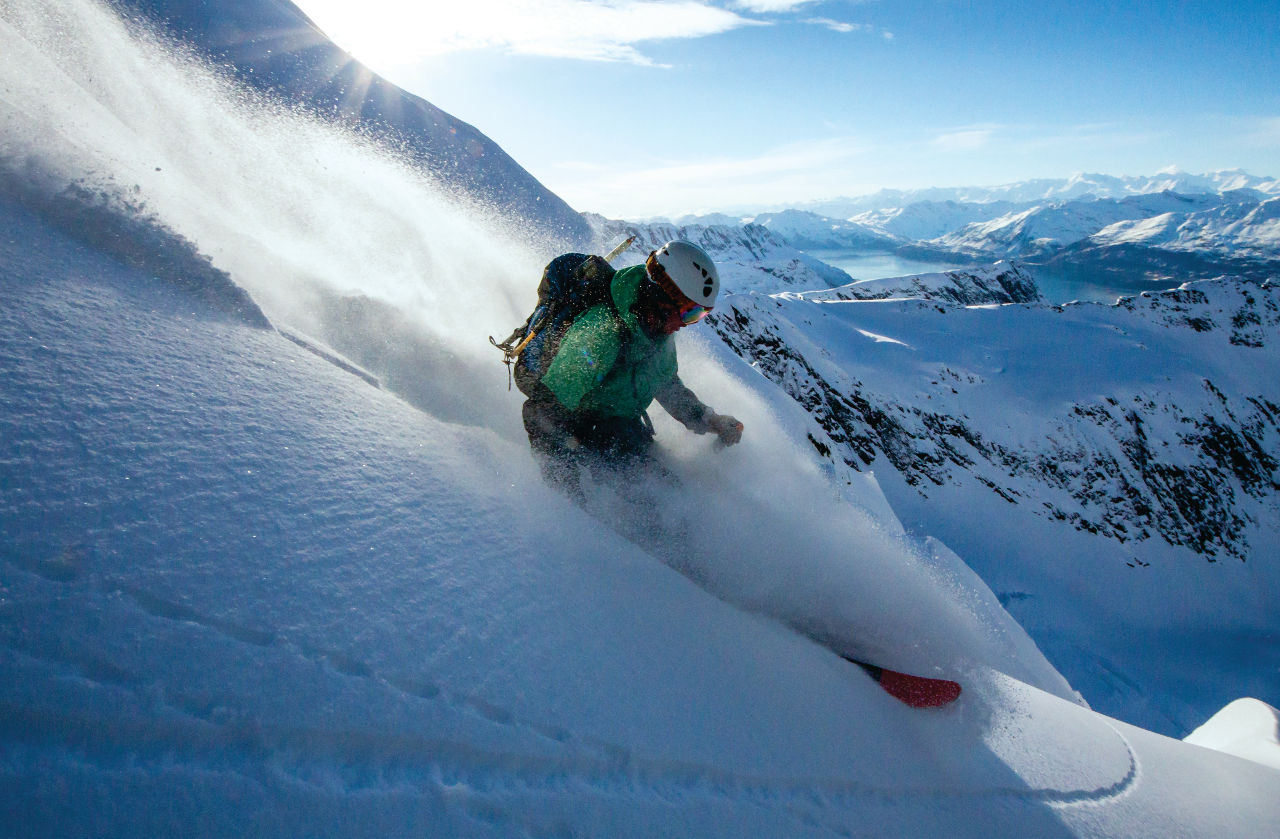 Heli Skiing Nate francis pow turn backlit by Josh Mandell Photography