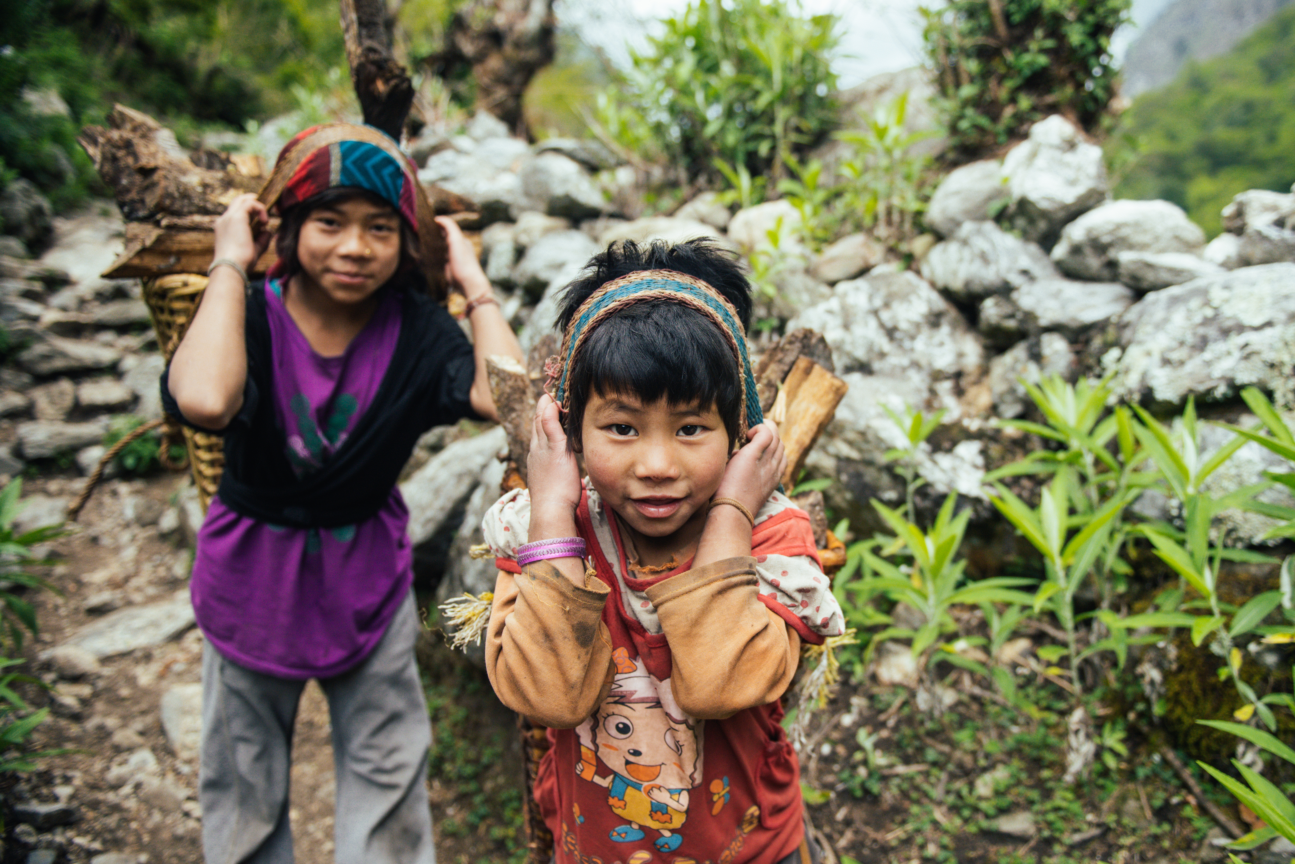 Children stop for a photo while carrying firewood down the trail - Gorkha Region.