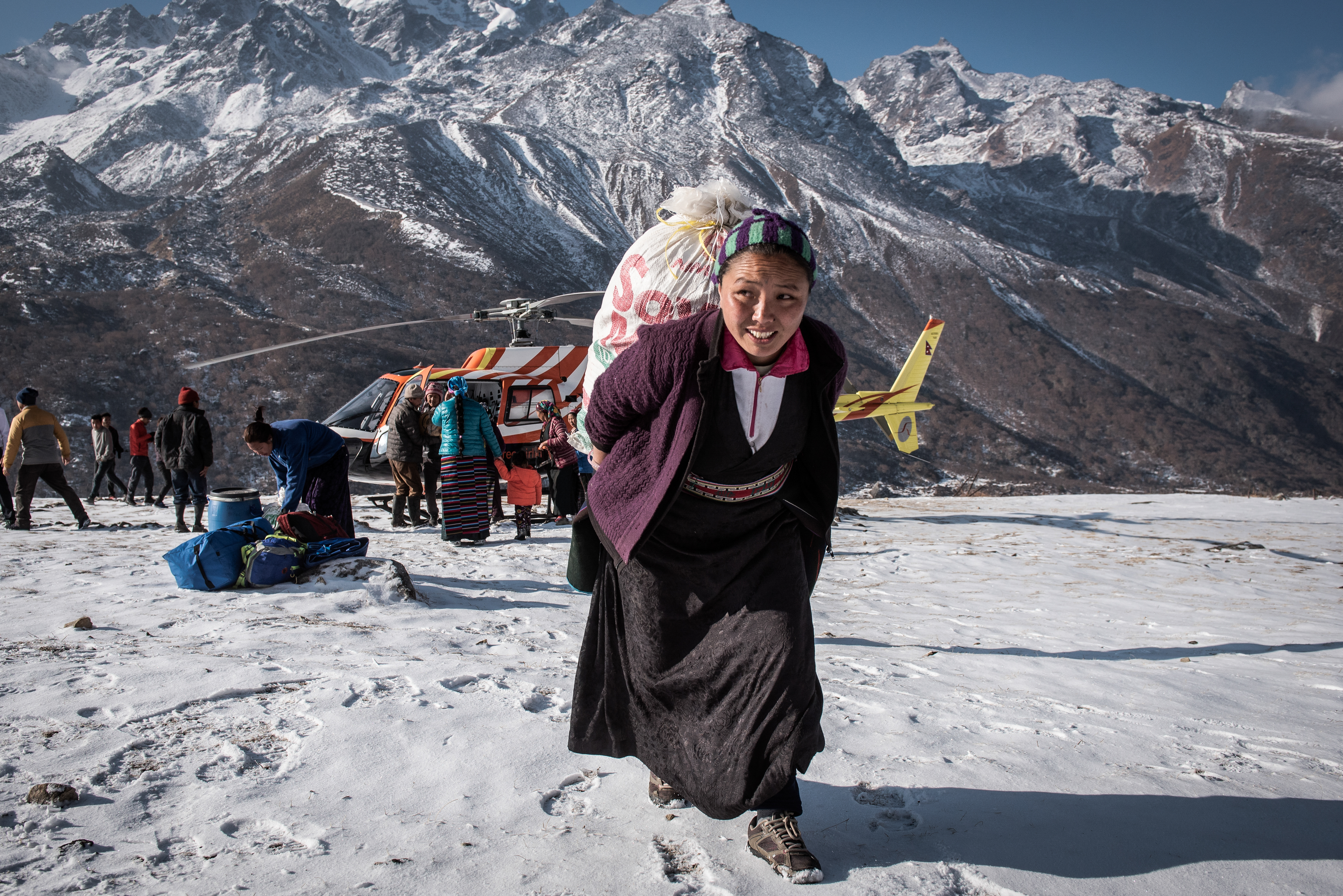 A local woman unloads supplies from a helicopter - Kyanjin Gompa.