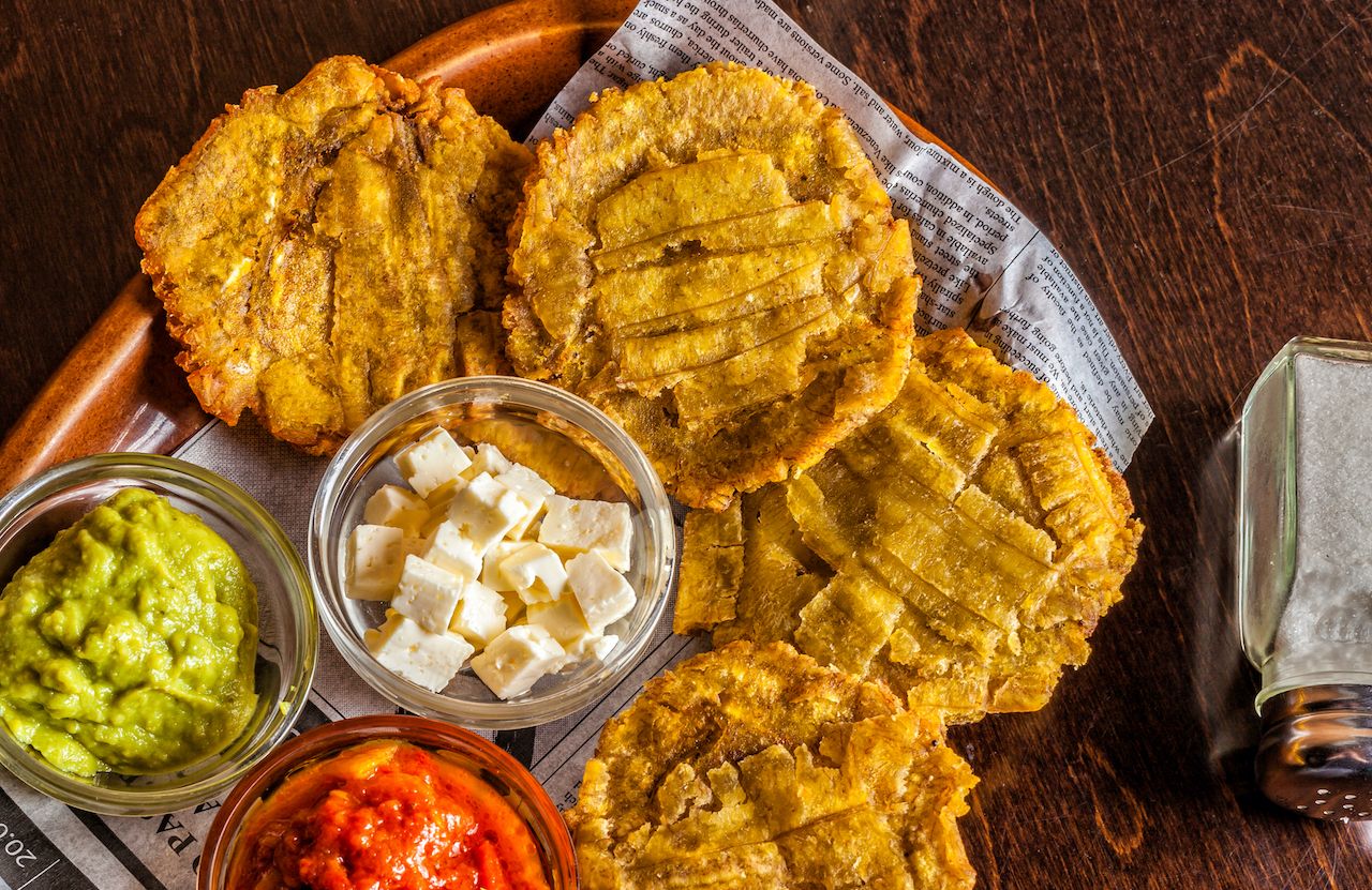 orange plate with tostones and dipping sauce - puerto rican food