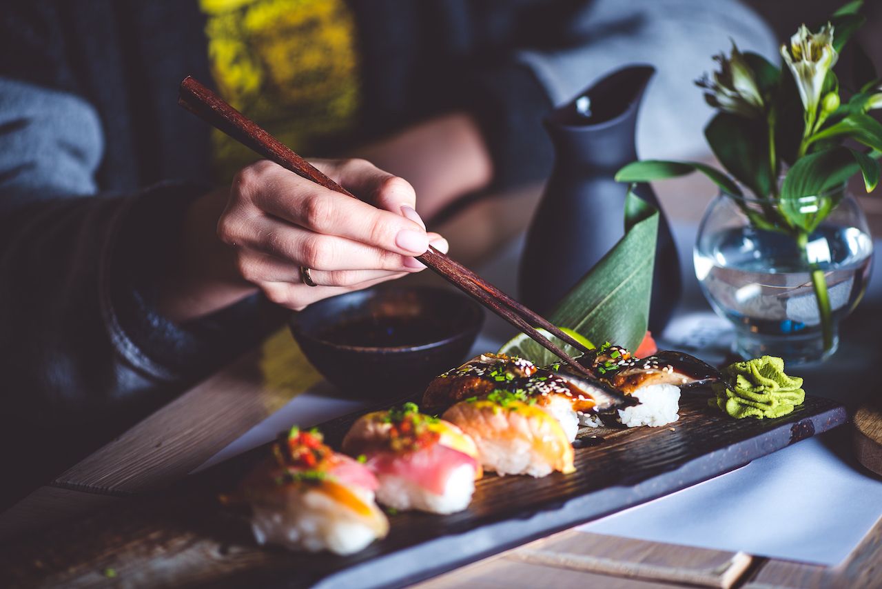 Man with chopsticks eating sushi