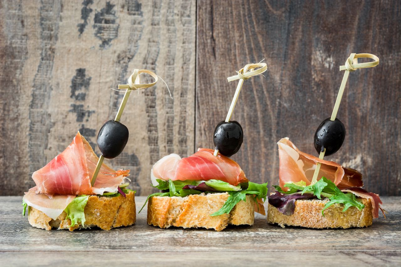 a tapas dish of Spanish ham with olives and lettuce
