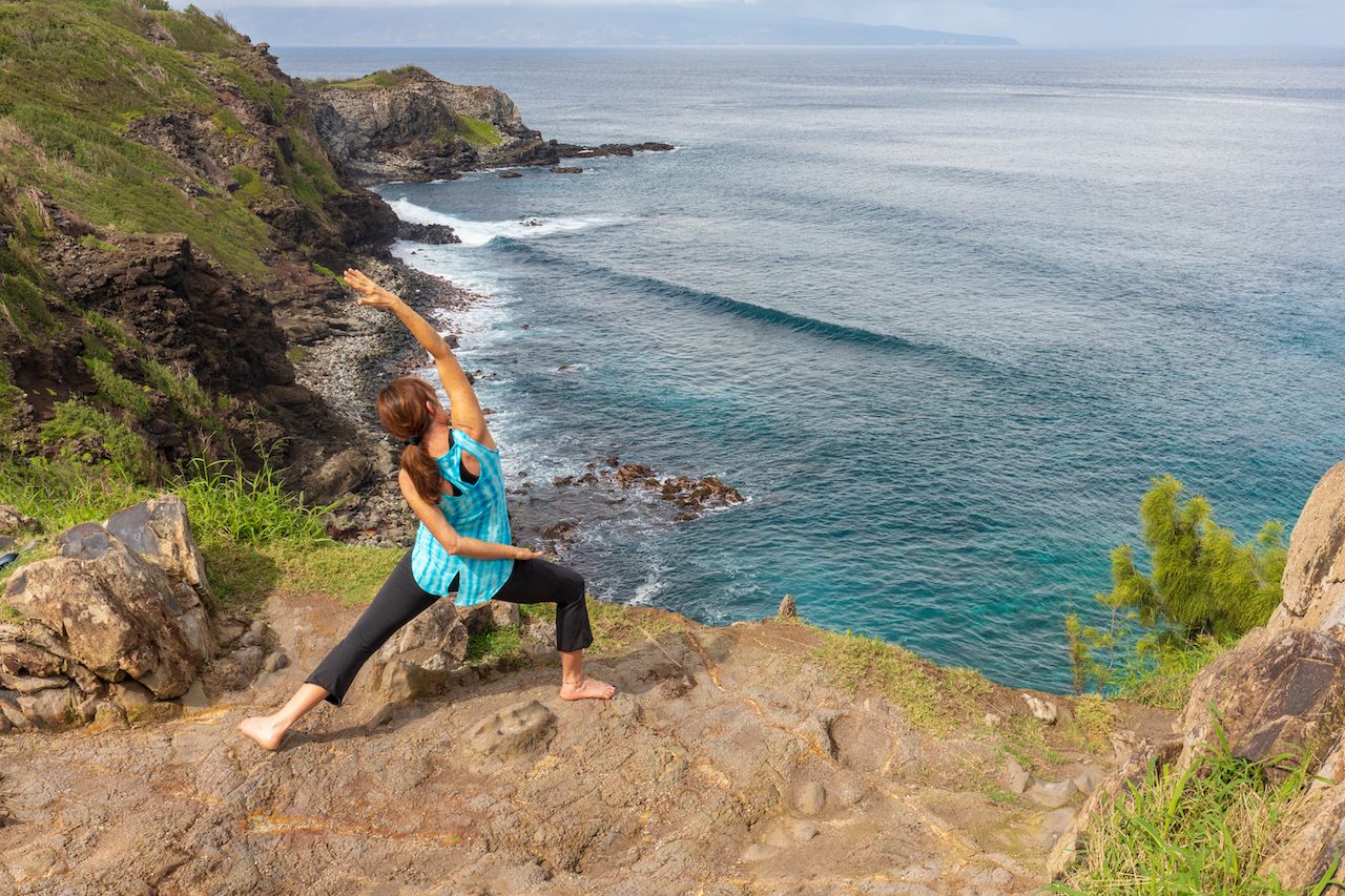 Woman practicing yoga on the Maui Coast