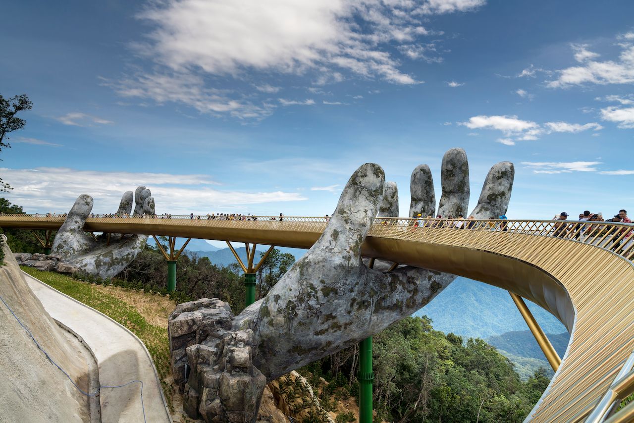 The Golden Bridge is lifted by two giant hands in the tourist resort on Ba Na Hill in Danang, Vietnam