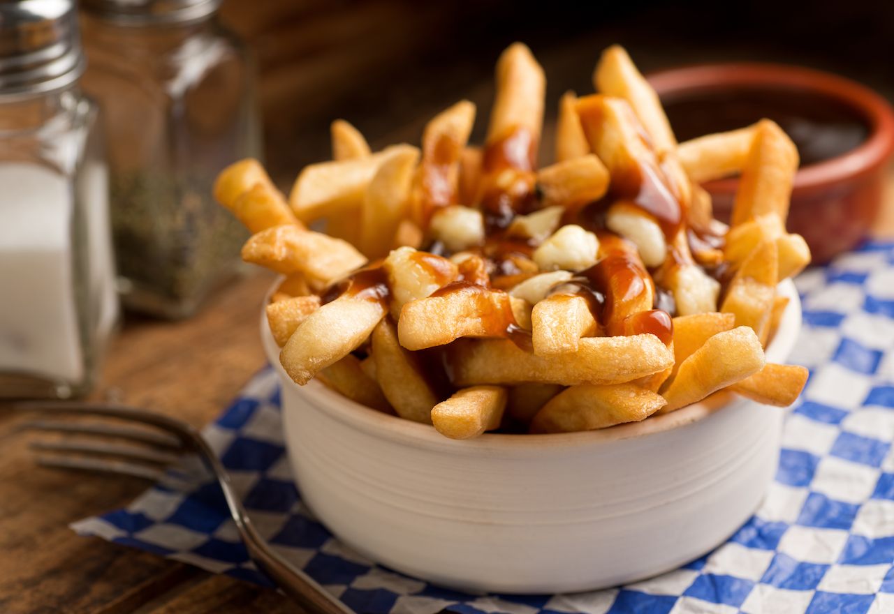 Bowl of Canadian poutine, fries topped with gravy and cheese curds