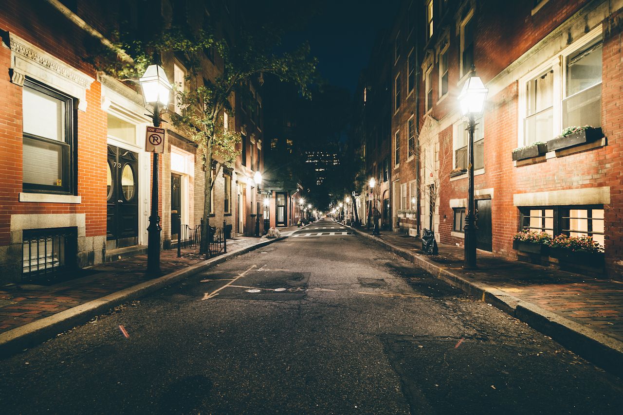 Lit lamposts on Beacon Hill street at night in Boston, Massachusetts