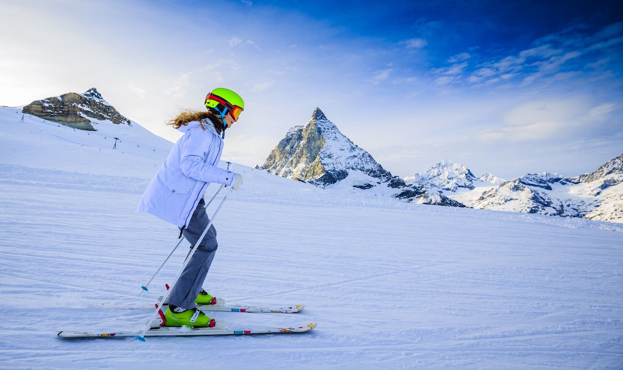 Teenage girl skiing in Swiss Alps in Sunny Day, Matterhorn in Background