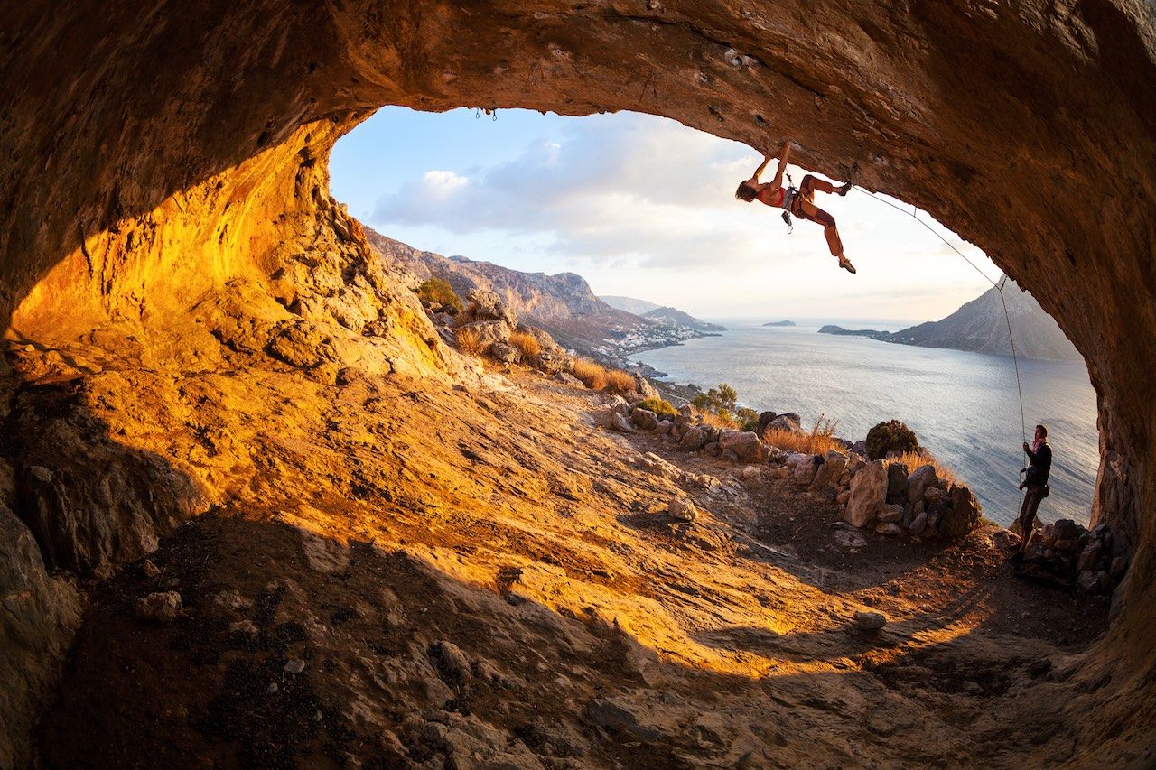 Woman climbing in a cave climbers