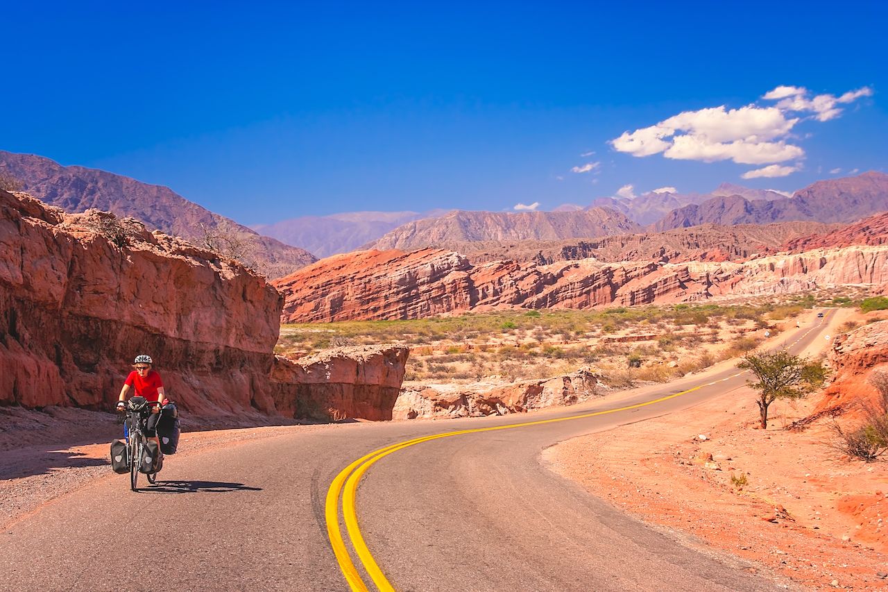 Woman cycling on the empty road to Cafayate in the remote part of north west Argentina