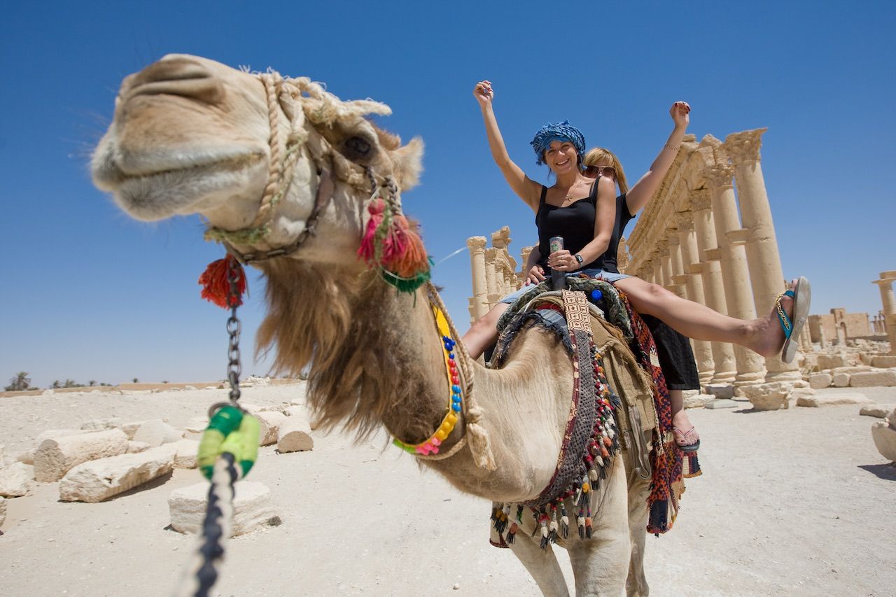 Women riding a camel in the Sahara desert