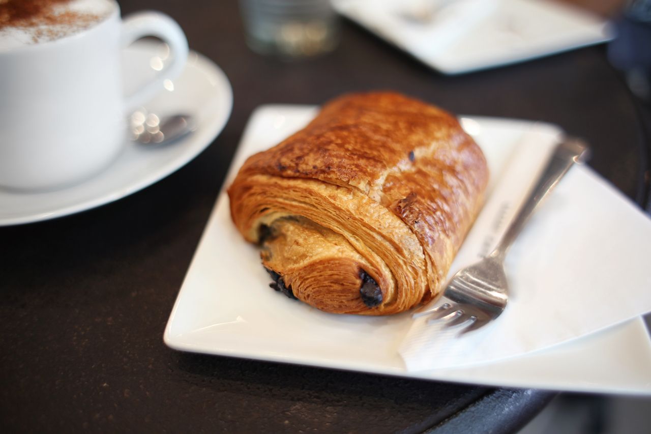Chocolate croissant and cappuccino on a table