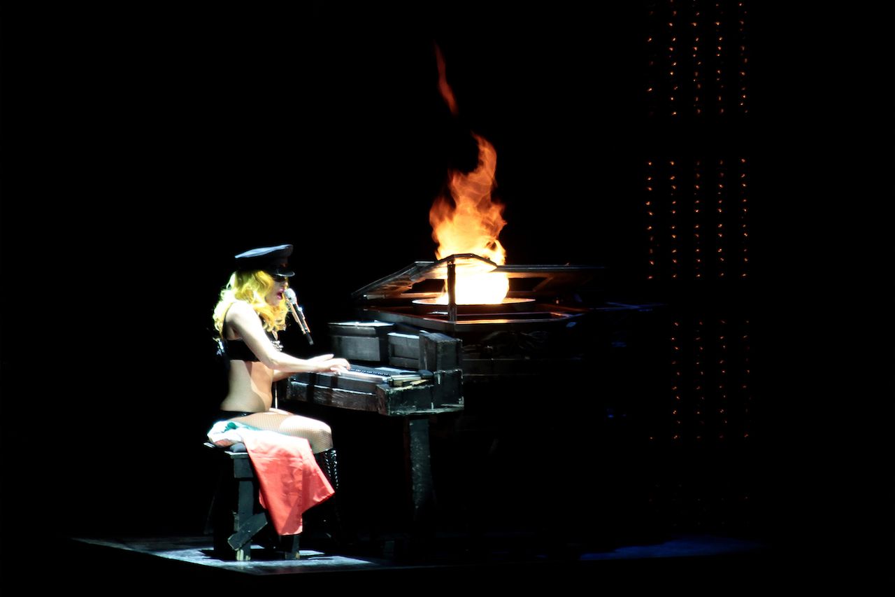 Lady Gaga performing with a flaming piano
