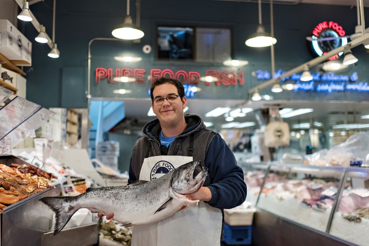 Man holding fish at Pike Place Market in Seattle, Washington, USA