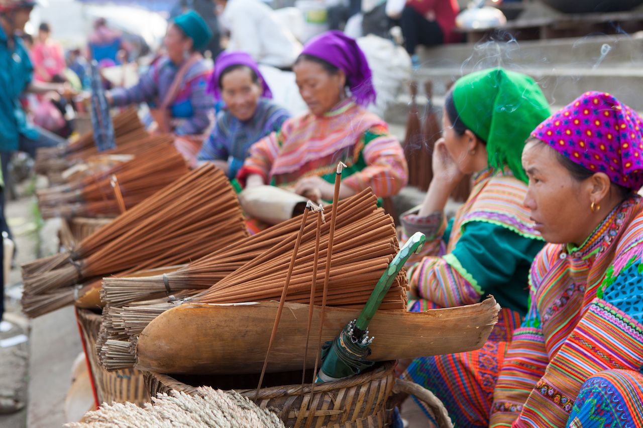Vietnamese Hmong minority women selling incense at Bac Ha traditional weekly flea market.