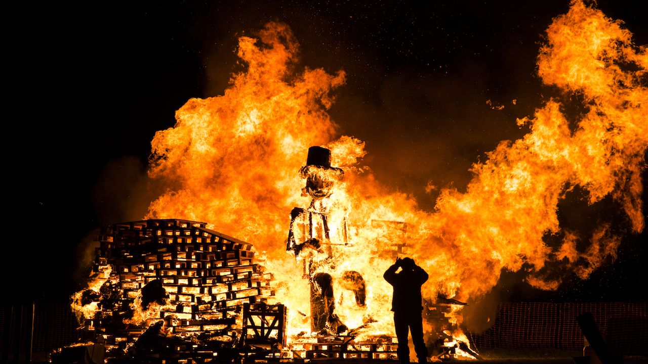 Man takes a picture during a bonfire the night of the fifth of November