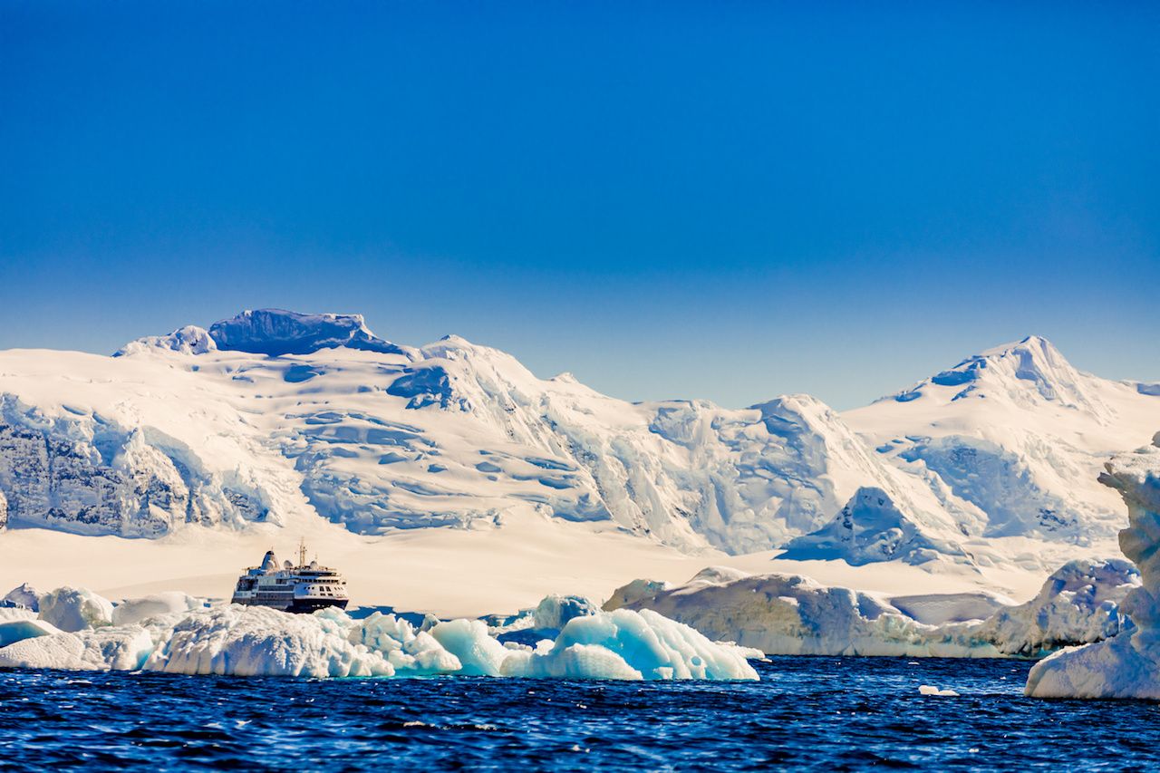 Antarctic cruise ship by glacier