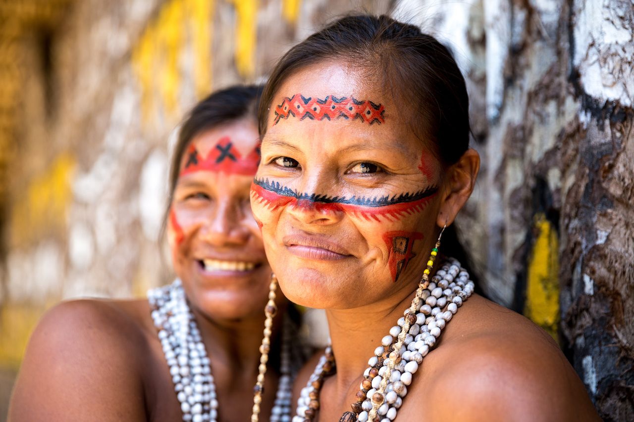 Native Brazilian women smiling at an indigenous tribe in the Amazon