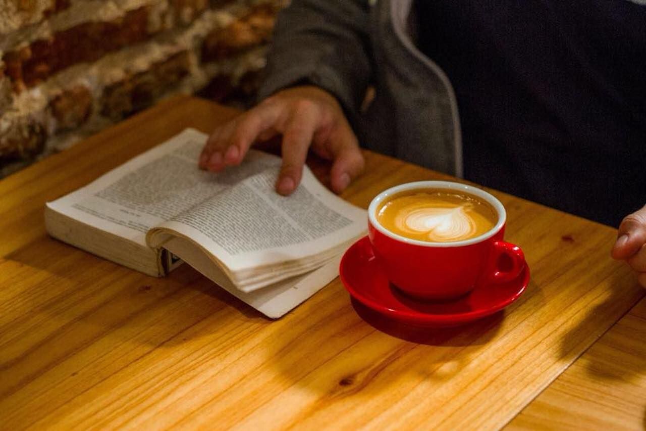 Person reading a book with coffee
