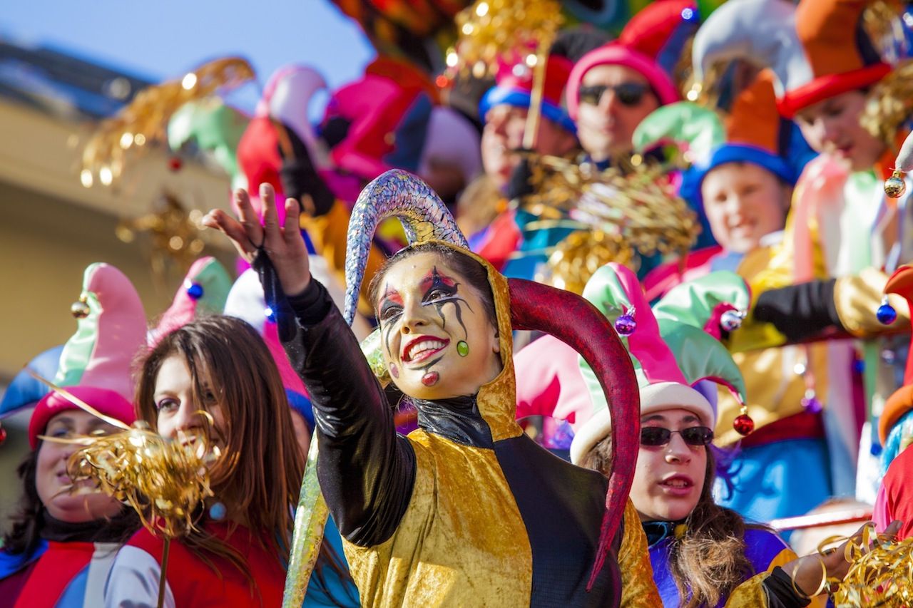 Festival, the parade of carnival floats with dancing people on streets of Viareggio