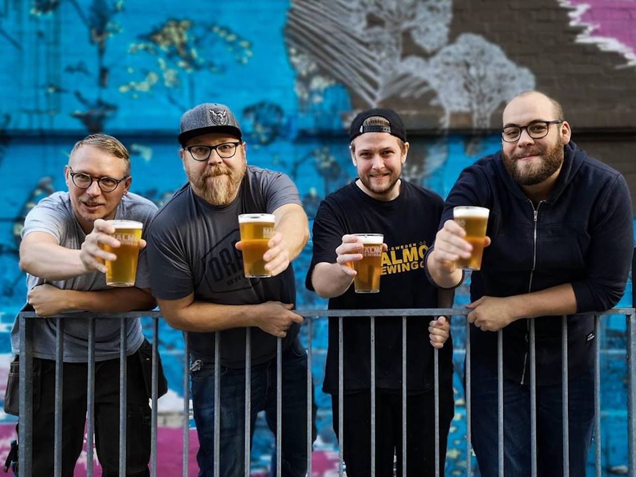 Four men holding beers