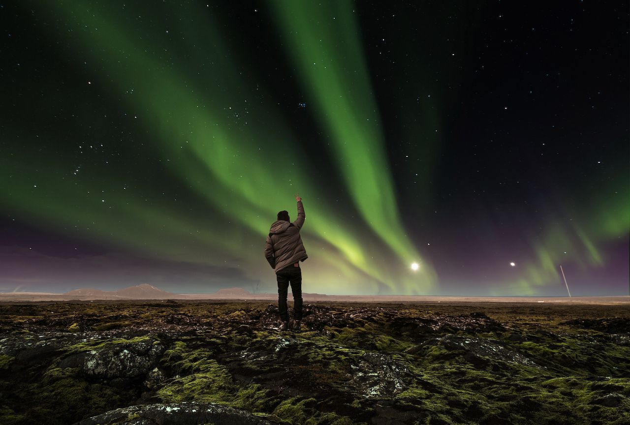 Man standing under the northern lights