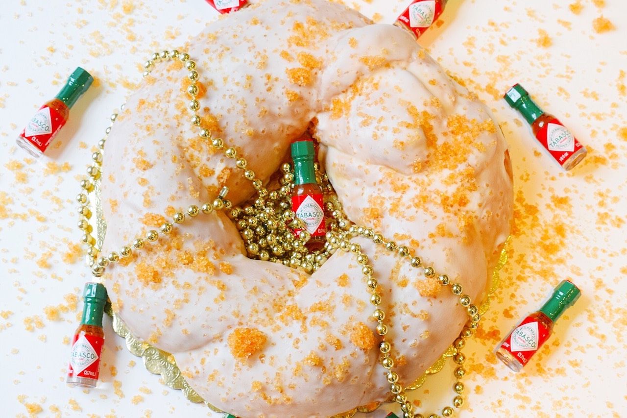 sucre king cake with gold beads and mini tabasco bottles