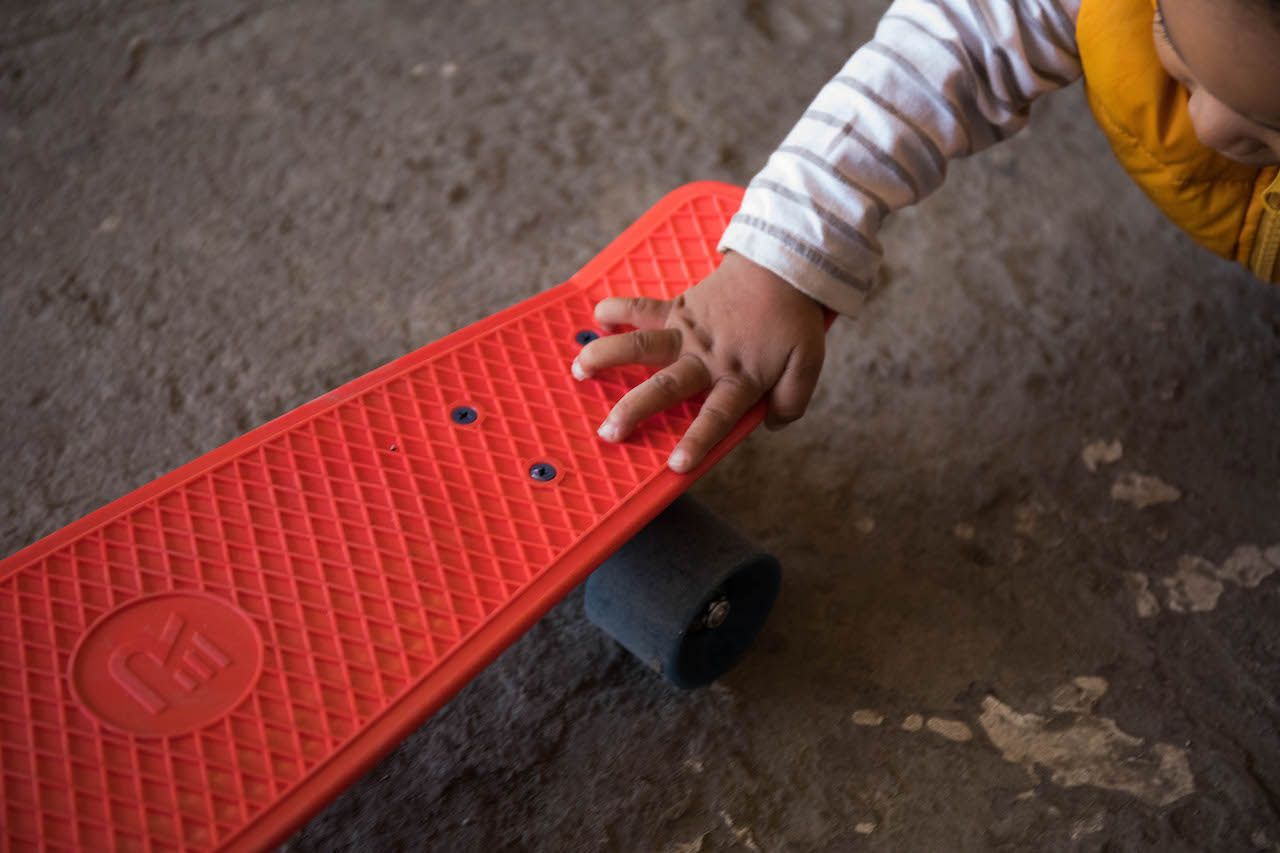 Baby playing with a mini skateboard