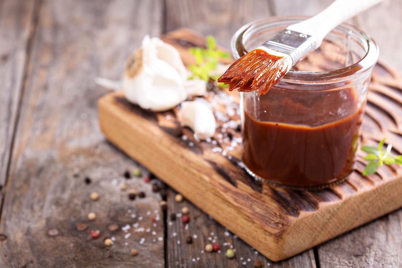 Barbecue sauce in a jar on a cutting board