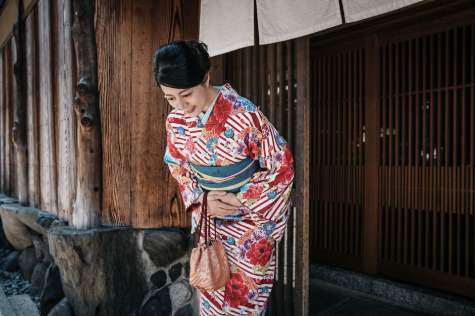 Japanese woman bowing wearing a kimono