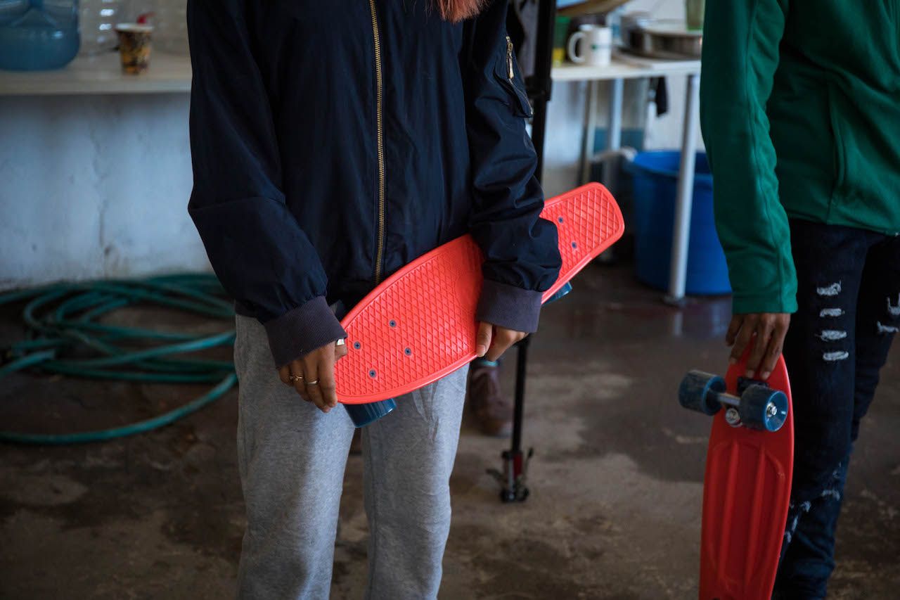 Mexican migrants holding skateboards