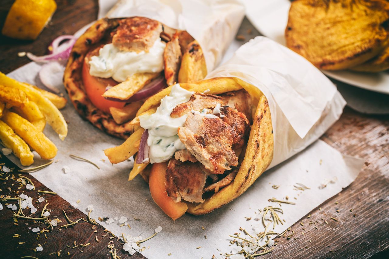 Gyros souvlaki wrapped in a pita bread on a wooden background