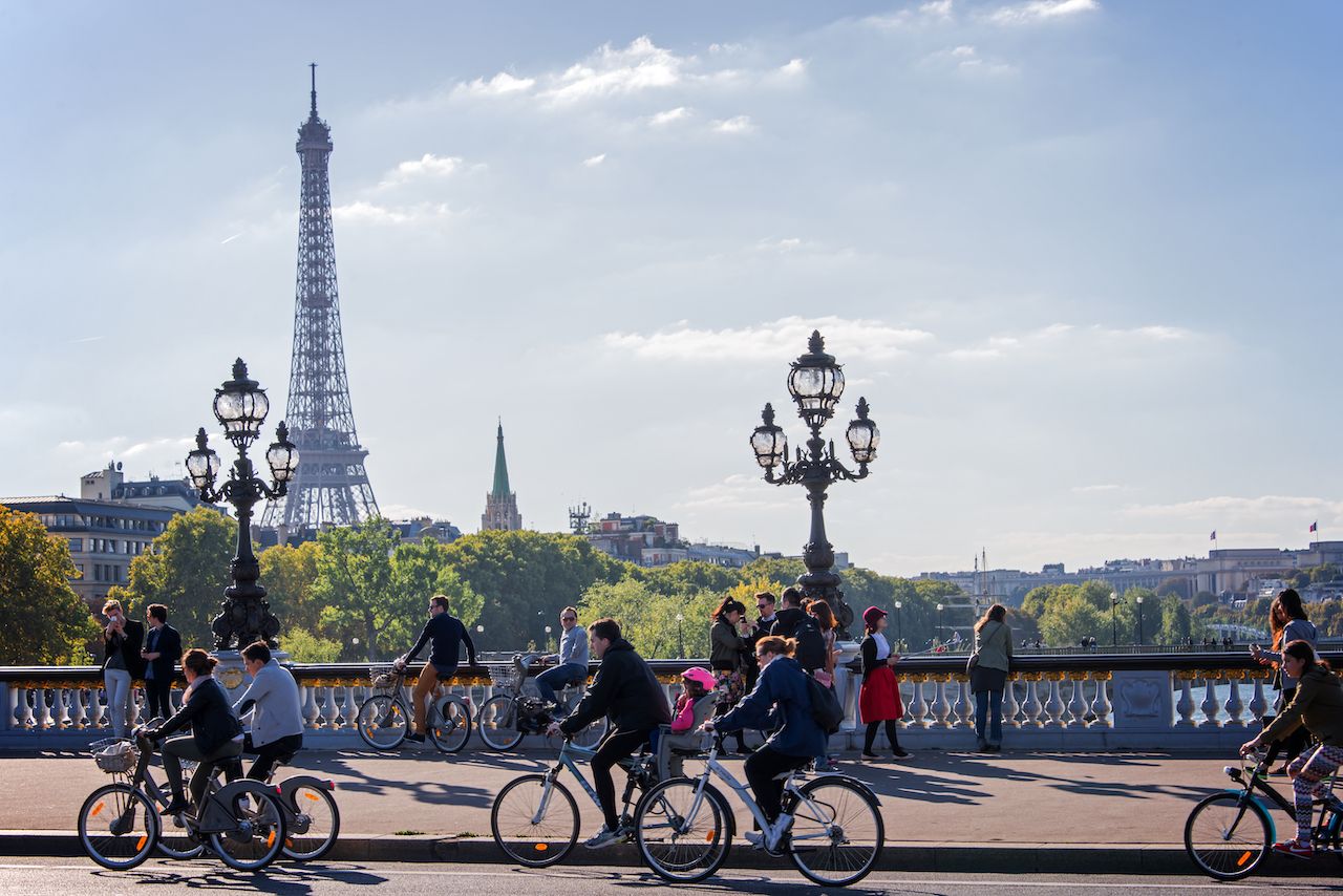People on bicycles and pedestrians enjoying a car free day on Alexandre III bridge in Paris