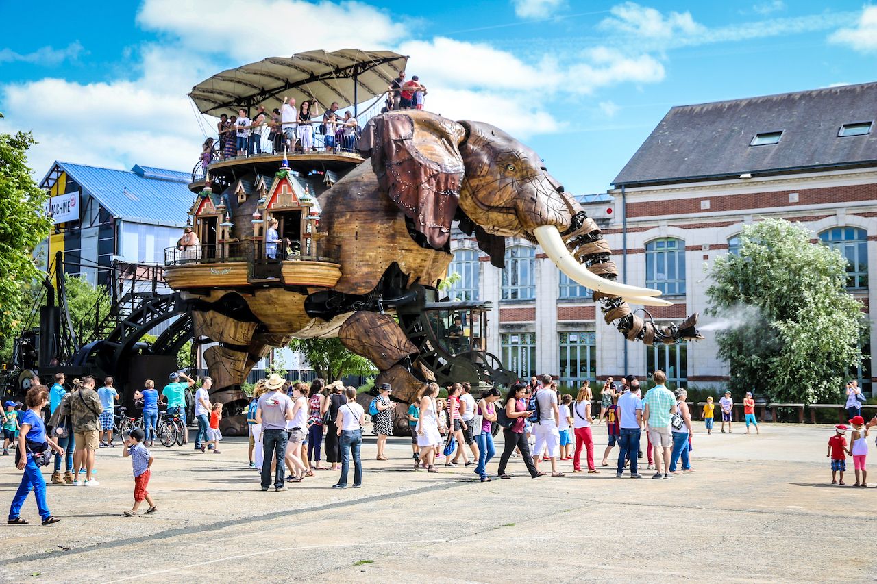 The Great Elephant of the Machines de l'Ile carrying passengers in city square in Nantes, France