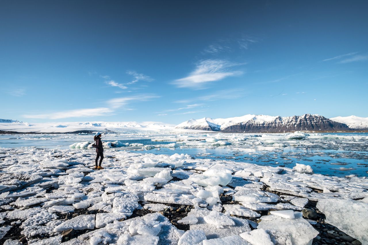 A girl traveler is looking at Jokulsarlon Glacier Lagoon, Iceland
