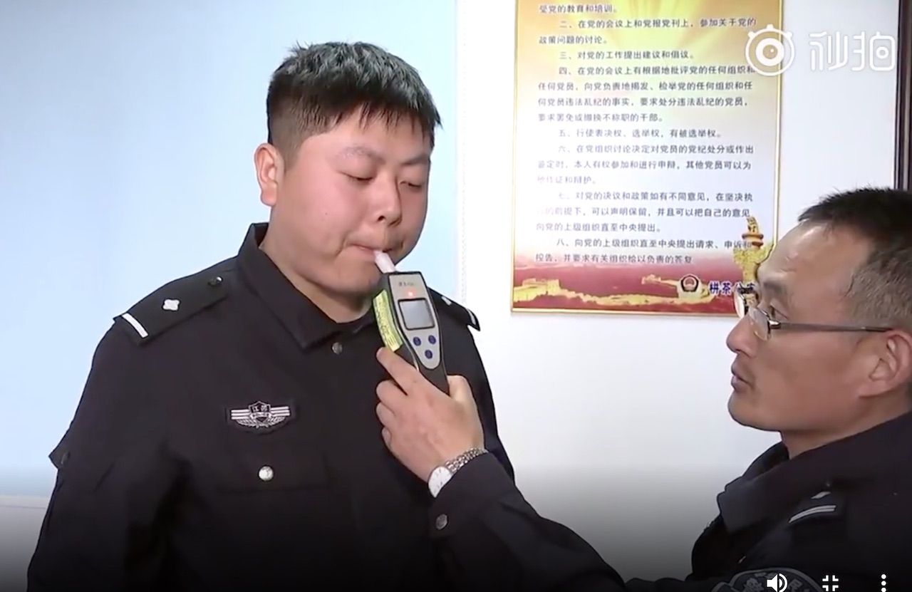 Chinese police officer taking a breathalizer test about eating Durian