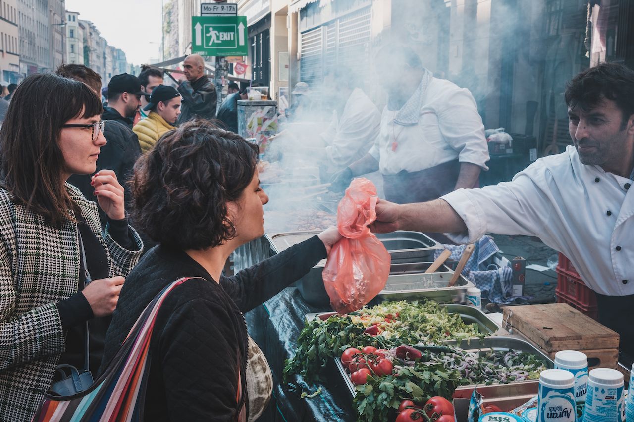 Girl buying turkish street foodin Berlin, Kreuzberg