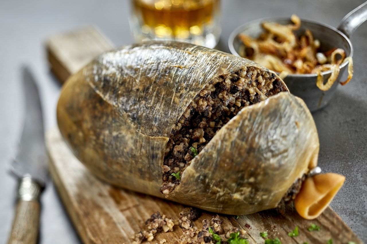 plate of Haggis cut open with knife - scottish foods