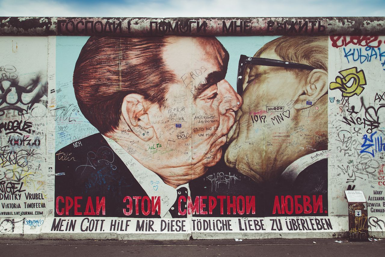 Street art graffiti painting 'The Kiss' by Dmitri Vrubel at famous East Side Gallery, the Berlin Wall, Berlin