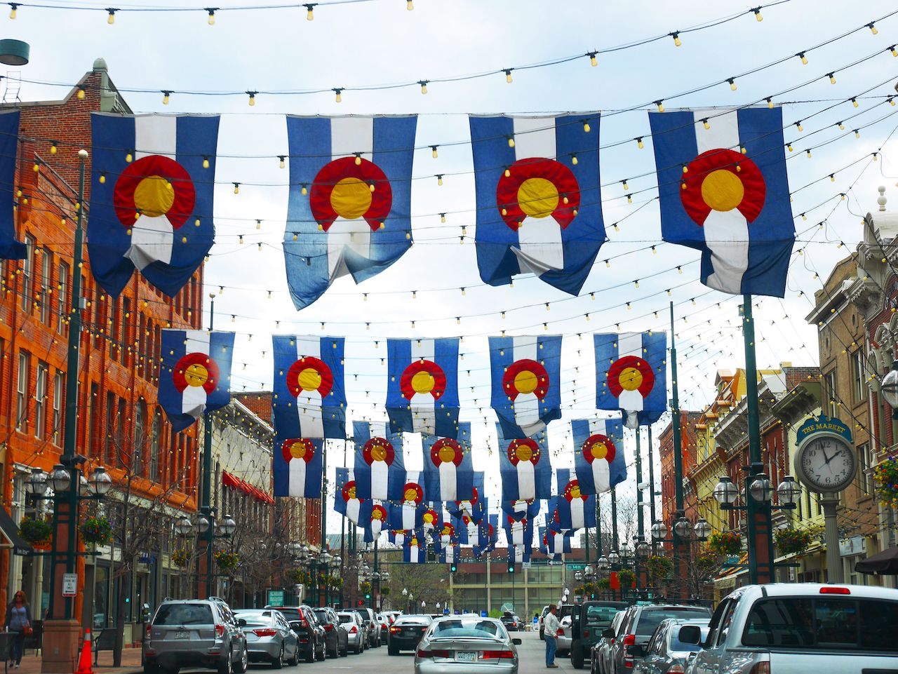 Traffic in downtown Denver with cars and hanging state flags