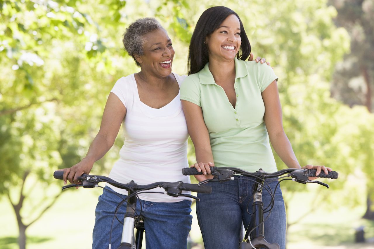 Two women on outdoors bikes smiling