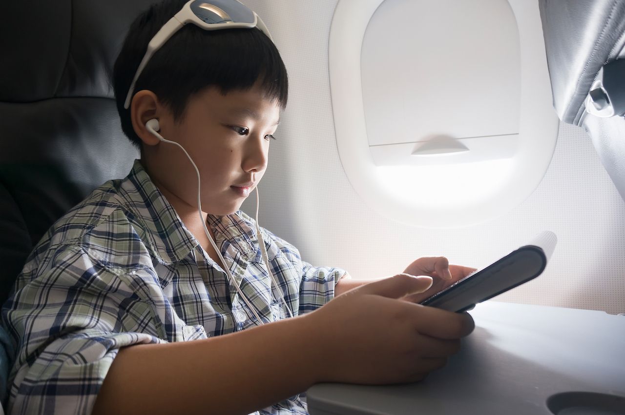 Child using a tablet on a plane