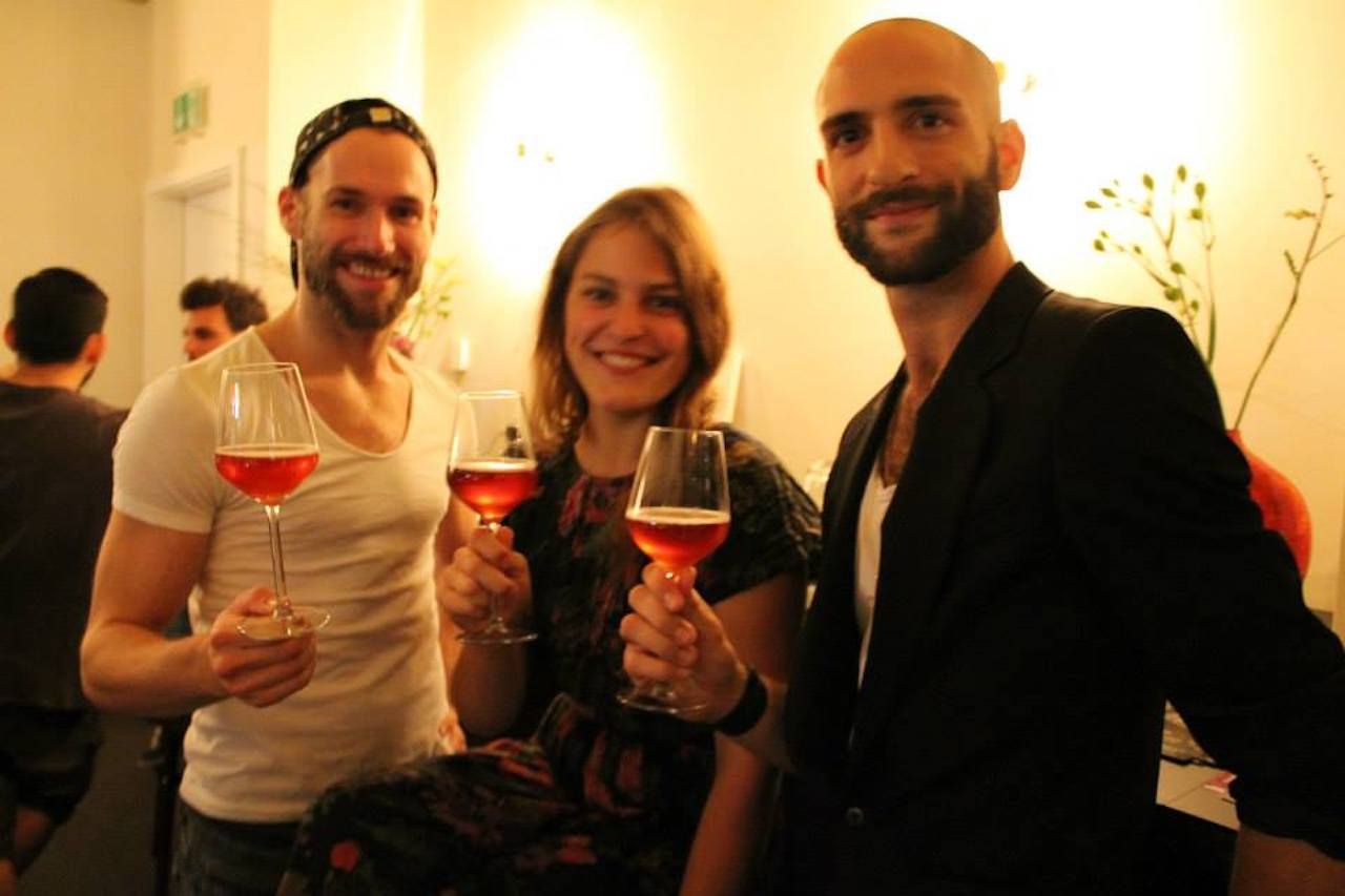 Three people holding wine glasses