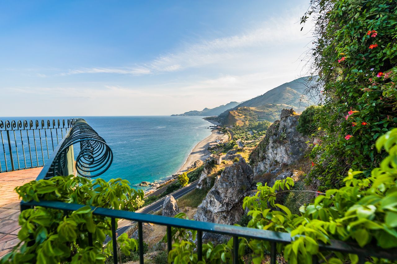 Amazing sunny mediterranean coast viewed from beautiful wrought iron balcony in Sicily, Italy