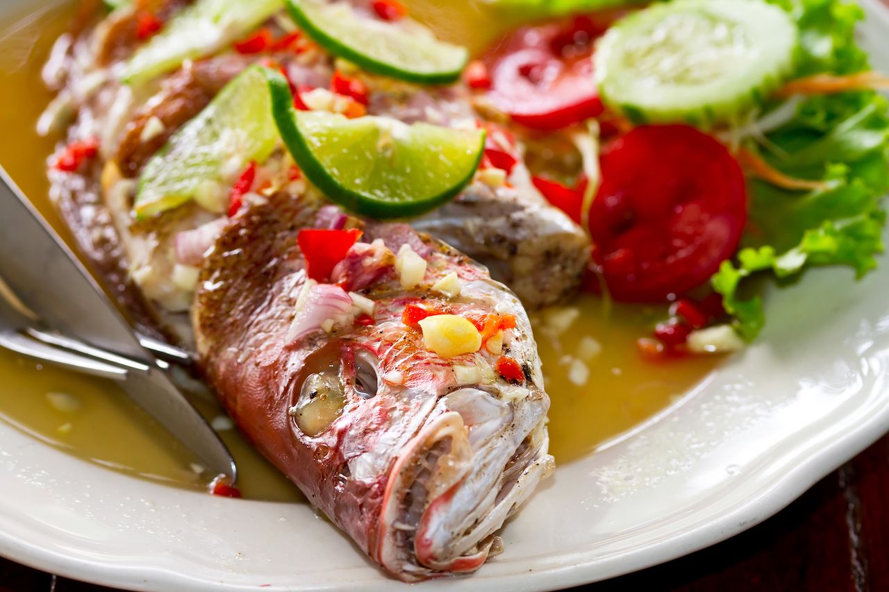 Dinner with freshly prepared Thai style whole red snapper fish