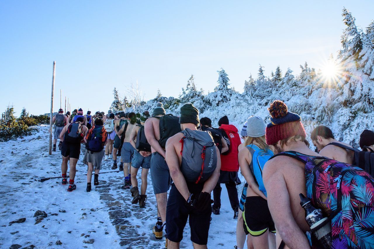 large group of people walking and doing wim hof method of breathing in the cold