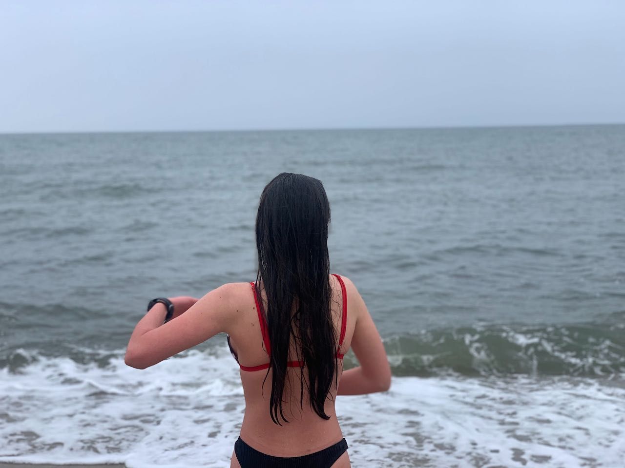 girl in front of cold ocean doing Wim hof method